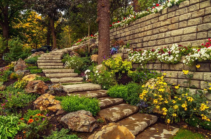 Retaining wall with flowers and stairs. flower bed designs